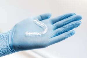 clear dental retainer on blue gloved hand 2026 03 19 07 55 53 utc